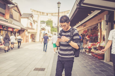 Man using mobile phone while standing in market