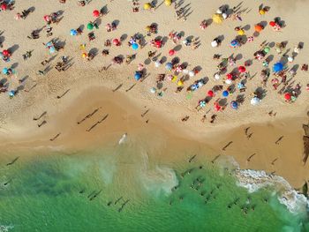 Aerial view of people enjoying on sand at beach