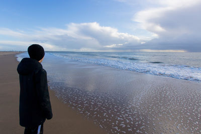 Rear view of man standing on beach