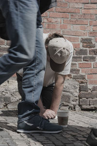 Low section of man holding coffee cup