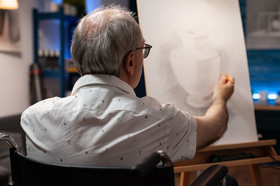 Rear view of man sitting on chair