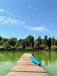 Scenic view of lake against blue sky with kayak in the foreground 