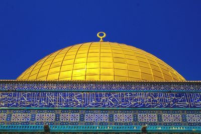 Low angle view of ornate building against blue sky