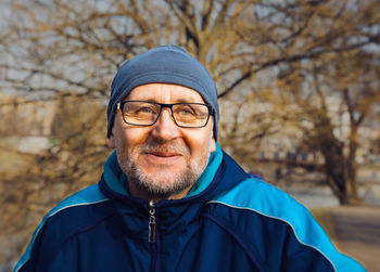 Close-up of man in eyeglasses looking away at park