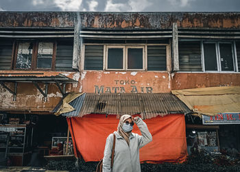 Portrait of man photographing against building