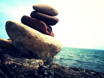 Close-up of rocks on beach against sky