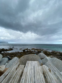 Scenic view of picnic bench and sea against sky