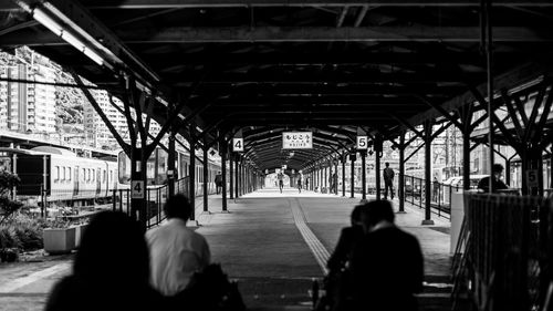 Rear view of people walking on railway station