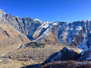 Scenic view of snowcapped mountains against clear blue sky