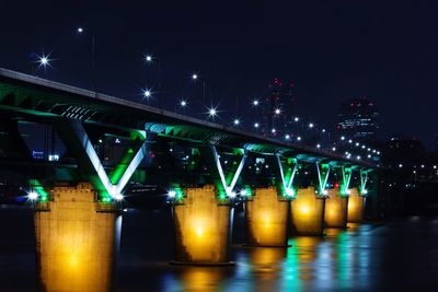 Illuminated bridge against sky in city at night