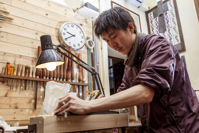 Side view of carpenter working in factory