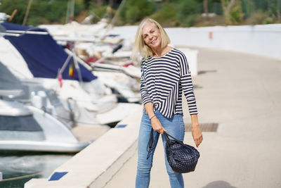 Portrait of smiling young woman standing on street