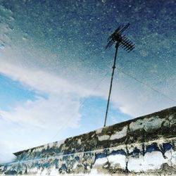 Reflection of antenna and sky in puddle