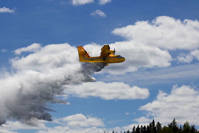 Low angle view of airplane flying against sky