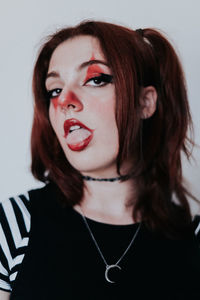 Close-up of young woman against white background