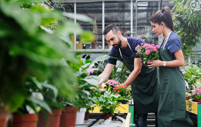 Man and woman standing in greenhouse