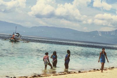 People on beach against sky