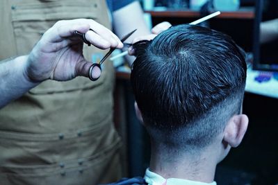 Midsection of barber cutting hair of customer