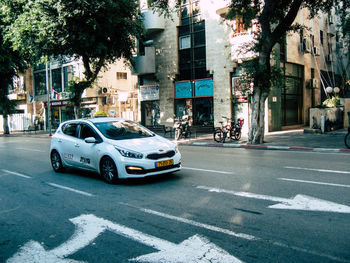 Cars on road by buildings in city