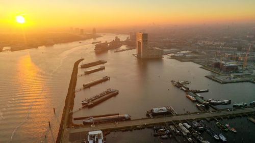 High angle view of city at riverbank during sunset