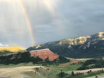 Scenic view of rainbow over landscape against sky