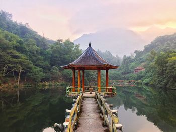 Gazebo by lake against sky