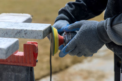 Midsection of worker using grinder