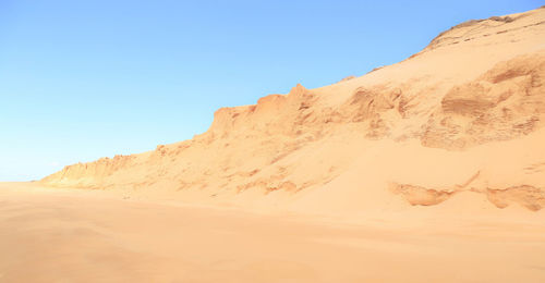 Sand dunes in desert against clear sky