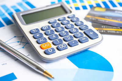 High angle view of calculator and pen and documents on table