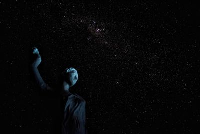 Low angle view of man against star field at night