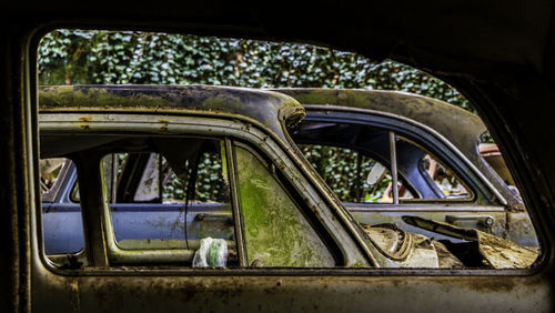 Abandoned vehicles, rusty, view of windows.