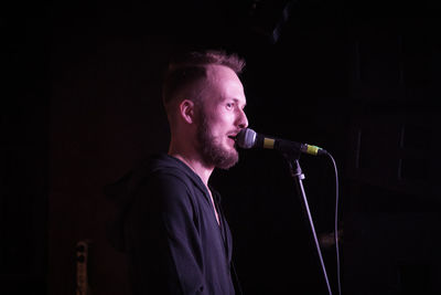 Side view of singer singing at event