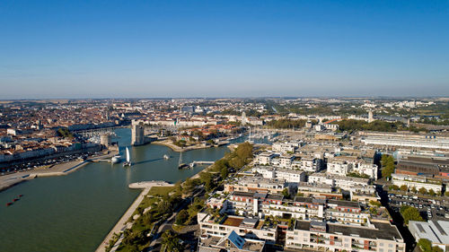 High angle view of city by river against sky