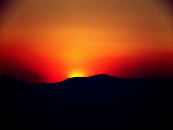 Scenic view of silhouette mountain against sky at sunset