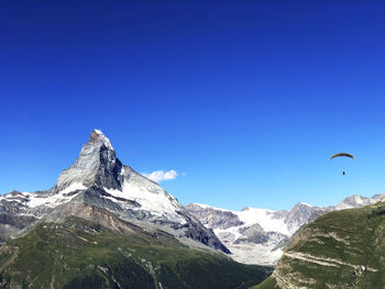 Scenic view of snowcapped mountains against clear blue sky