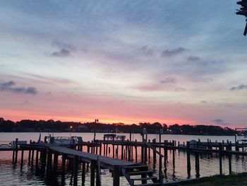 Pier over lake against sky during sunset