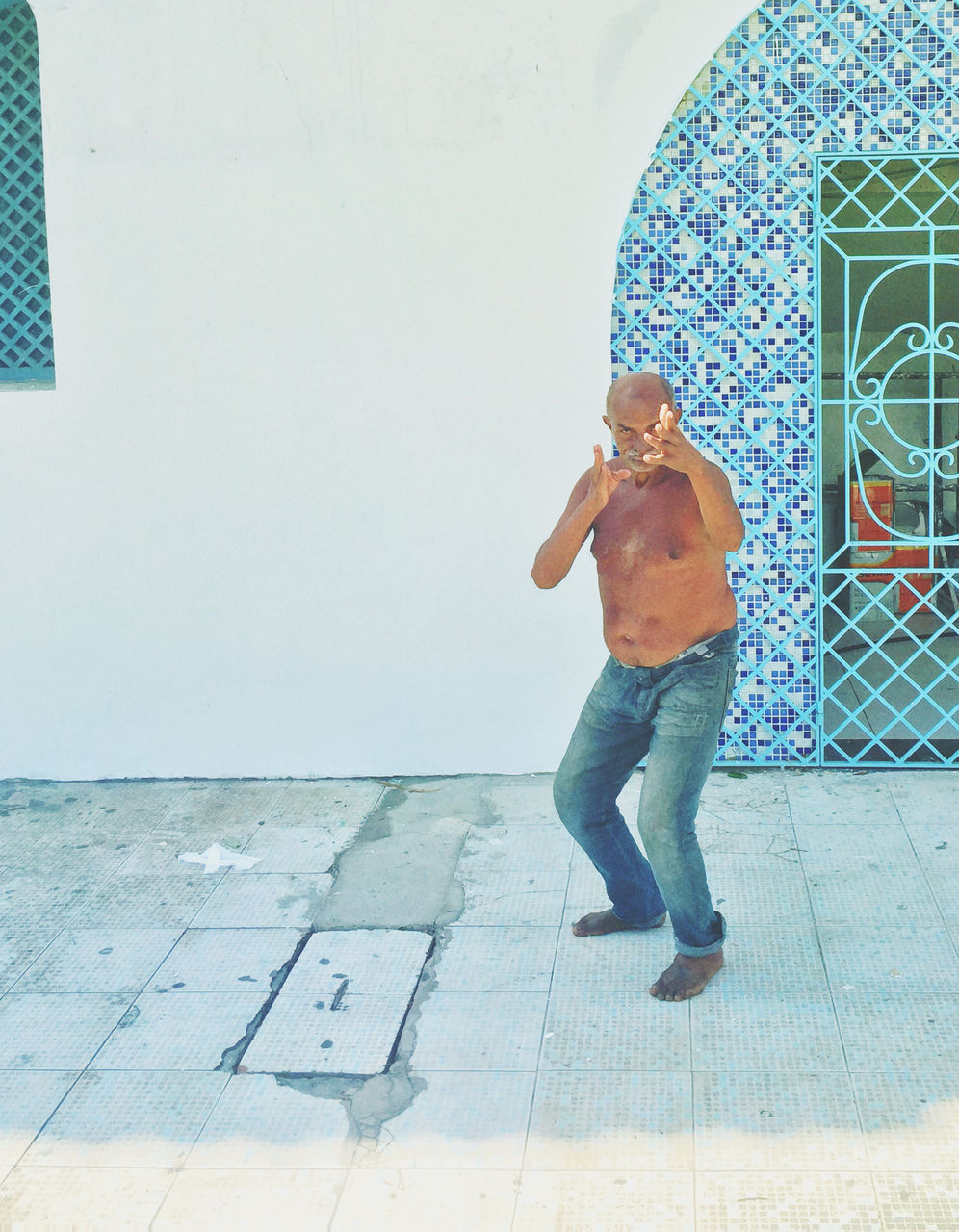 full length, casual clothing, lifestyles, leisure activity, standing, wall - building feature, built structure, person, architecture, childhood, young adult, front view, building exterior, day, arms outstretched, sunlight, boys, blue