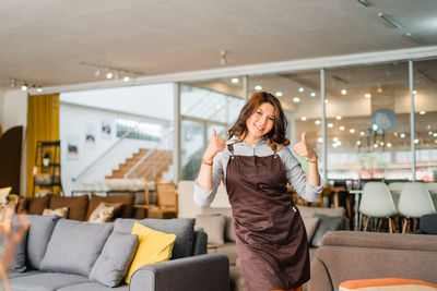 Young woman using mobile phone while sitting in cafe