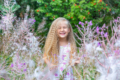 Portrait of smiling girl with purple flowering plants