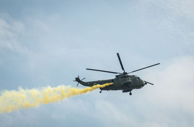 Low angle view of helicopter flying against sky