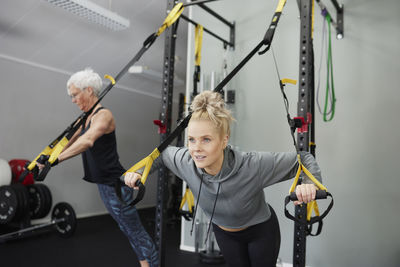 Woman using training equipment in gym