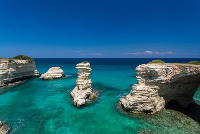 Panoramic view of rocks in sea against blue sky