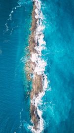 Aerial view of rock formations amidst sea