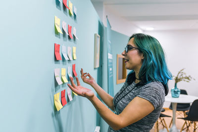 Portrait of a young woman with blue hair working in the office