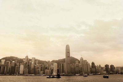 Buildings in city against cloudy sky