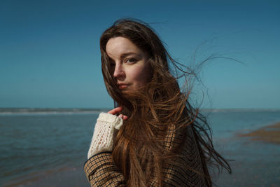 Portrait of woman on beach against sky