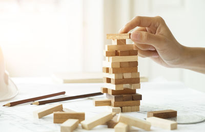 Cropped hand of man making wooden block stack