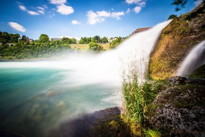 Scenic view of waterfall against sky