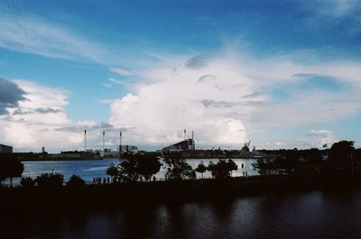 Buildings in city against cloudy sky