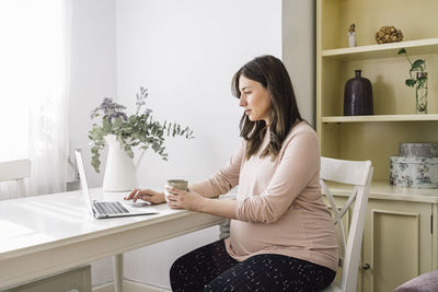 Woman sitting on table at home